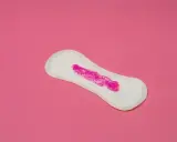Compresa con brillo rosa simulando que la regla solo mancho al limpiarme.