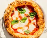 Eine köstliche Pizza Margherita mit geschmolzenem Mozzarella, Tomatensauce und frischem Basilikum. Perfekt für ein einfaches Pizza Margherita Rezept.