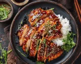 Saftiges Hähnchen Teriyaki, glasiert und mit Sesam bestreut, serviert mit Reis und Frühlingszwiebeln.
