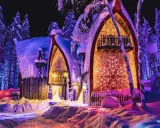 Noche mágica en Finlandia con niños. Casas nevadas iluminadas con luces de colores, rodeadas de árboles cubiertos de nieve.