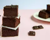 Ciemne, wilgotne brownie z fasoli, ułożone w wieżę, obok kawałków czekolady.