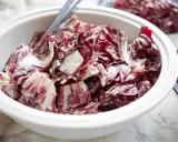 Ein cremiger Radicchio Salat in einer weißen Schüssel, bereit zum Servieren.
