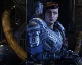 Kait Diaz w zbroi z Gears of War 5, z warkoczem i czerwoną opaską na włosach, w tle industrialne otoczenie.
