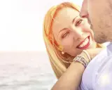 Uśmiechnięta blondynka patrzy na ukochanego, czując lekkość i swobodę, jak w luźnym związku.