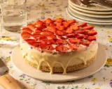 Deliciosa tarta de frutas cubierta de fresas frescas y glaseado blanco cremoso.