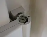 Mécanisme de réglage gond porte, avec une molette crantée et un axe carré pour ajuster la position.