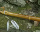 Flûte en bambou, ornée d'un oiseau sculpté et de plumes, prête à fabriquer des mélodies naturelles.