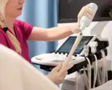 Lekarka przygotowuje sondę USG, aplikując żel. Badanie oceni m.in. grubość endometrium normy.