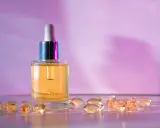 Buteleczka z serum i kapsułki na fioletowym tle. Wybór między retinol czy retinal dla pięknej skóry.