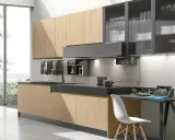 Cucina moderna con ante in legno chiaro e pensili in vetro rigato. Ottime idee cucina piccola per sfruttare ogni spazio.
