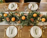 Vackert dukat julbord med granris, apelsiner med nejlikor, torkade apelsinskivor och ljus. En perfekt inspiration för att dekorera julbordet.