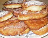 Stos puszystych racuchów bez drożdży, posypanych cukrem pudrem, wygląda apetycznie.