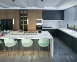 Moderne Küche mit Marmor-Arbeitsplatte, dunklen Schränken und Akzenten aus Holz. Die Lichtplanung im Neubau setzt die elegante Atmosphäre perfekt in Szene.