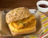 Panino con pane e panelle fritte, un classico street food siciliano, servito su un vassoio con carta da forno e una ciotolina di salsa.