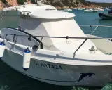Bateau blanc à quai, avec pare-battages bleus et blancs. Le numéro d'immatriculation est visible, ainsi qu'un dauphin peint sur la coque. Fiche technique du Arvor 20.