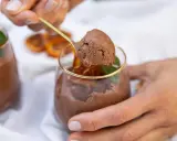 Delicioso mousse de chocolate, perfecto para los postres de Nochevieja. Una cucharada dorada revela su textura aireada.