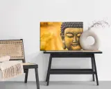 Buddha-tavla med matt material bredvid en stol med pläd och ett bord med en vas.