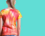 Dziewczynka w koszulce tie dye w odcieniach czerwieni i żółci.