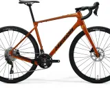 Pomarańczowy rower gravelowy Merida Silex 4000 z napędem Shimano GRX i oponami Maxxis Rambler.