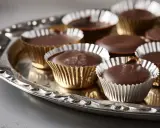 En bricka med hemgjorda ischokladpraliner i guldfärgade pappersformar. Perfekt för ett enkelt ischoklad recept.