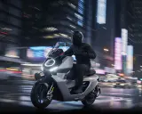Un motard en casque noir file sur une trottinette électrique futuriste sous une pluie battante, les lumières de la ville floues en arrière-plan.