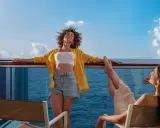 Due donne si godono il sole sul ponte di una nave, con il mare blu all'orizzonte. Una carta costa ideale per una vacanza rilassante.