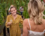Lachende junge Frau mit Weinglas im Weinberg an der Saale-Unstrut.