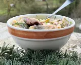 En skål med inlagd sill, dill och blommor. Perfekt för ett svenskt midsommarfirande eller som en del av ett inlagd sill recept.