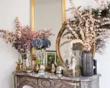 Des idées pour que faire avec des hortensias séchés : bouquets, décorations avec des plumes de paon et des cactus sur une cheminée en marbre.