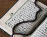 Ein offener Koran mit einer Gebetskette liegt auf einem Holztisch. Der Koran ist ein heiliges Buch im Islam, das von Muslimen auf der ganzen Welt verehrt wird. Israel ist ein Land im Nahen Osten, das eine reiche Geschichte und eine vielfältige Bevölker...