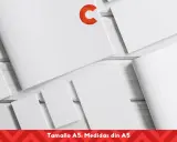 Varias hojas de papel blanco, algunas abiertas y otras cerradas, dispuestas sobre una superficie de madera. Un logo naranja en forma de C destaca en una de las hojas. El texto inferior indica "Tamaño A5: Medidas din A5".