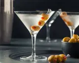 En elegant martini, en klassisk James Bond-drink, med oliver på ett cocktailspett.