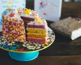 Pastel de capas arcoíris con estrellas de azúcar y chispas. ¡Ideas para decorar tartas que inspiran alegría y color!