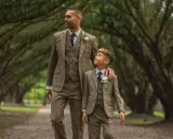A man and boy in matching tweed suits, a perfect example of what formal attire means for a wedding.