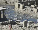 Ruinas de las termas de Yesa, con gente bañándose en las piscinas naturales formadas entre los escombros.