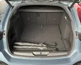 Maletero abierto de un Peugeot 308 SW con dos paraguas negros. Las medidas del maletero son amplias para equipaje.