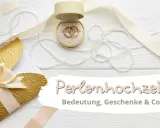 Hochzeitstags-Deko mit Ringen, Perlen und goldenem Umschlag. Die Perlenhochzeit Bedeutung wird hier gefeiert.