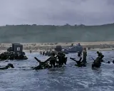 Soldati avanzano nell'acqua durante lo sbarco in Normandia. Un fotografo immortalò questo momento storico.