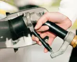 Dłoń trzymająca pistolet do tankowania, gotowa do nalania gazu do diesla.