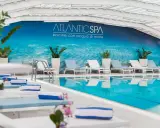 Rilassati nei bagni Riccione con piscina, un'oasi di benessere con lettini e teli blu.