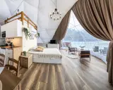 Przytulny glamping w Wielkopolsce: domek z aneksem kuchennym, wygodnym łóżkiem i widokiem na zimowy krajobraz.