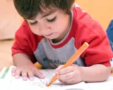 Bambino concentrato colora un disegno. A che età si capisce se un bambino è iperattivo? Osservare la sua attenzione e calma.