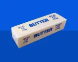 Ein Block Butter auf blauem Hintergrund. Bei Diabetes ist die Frage, wie viel Butter erlaubt ist.
