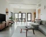 Salón moderno con sofá gris, mesa de centro y comedor. El color gris se combina con tonos madera y blanco, creando un ambiente sereno.