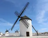 Molinos de viento blancos bajo un cielo azul. Un lugar que ver en Ciudad Real, como sacado de un cuento.