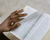 Dłoń przewracająca strony Biblii, szukająca pocieszenia w Psalmie 27.