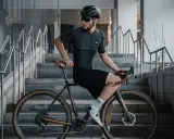Mężczyzna w stroju kolarskim siedzi na rowerze z ramą 48 cm, idealną dla osób o wzroście ok. 170-175 cm.