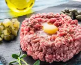 Un delicioso steak tartar con huevo crudo, alcaparras, pepinillos y aceite de oliva.