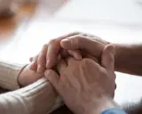 Dłonie splatają się w geście wsparcia, jak cicha prośba o sprzątanie po sobie w relacjach.