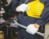 Obrero con casco amarillo y llave inglesa, listo para trabajar. Los epis son esenciales para su seguridad.